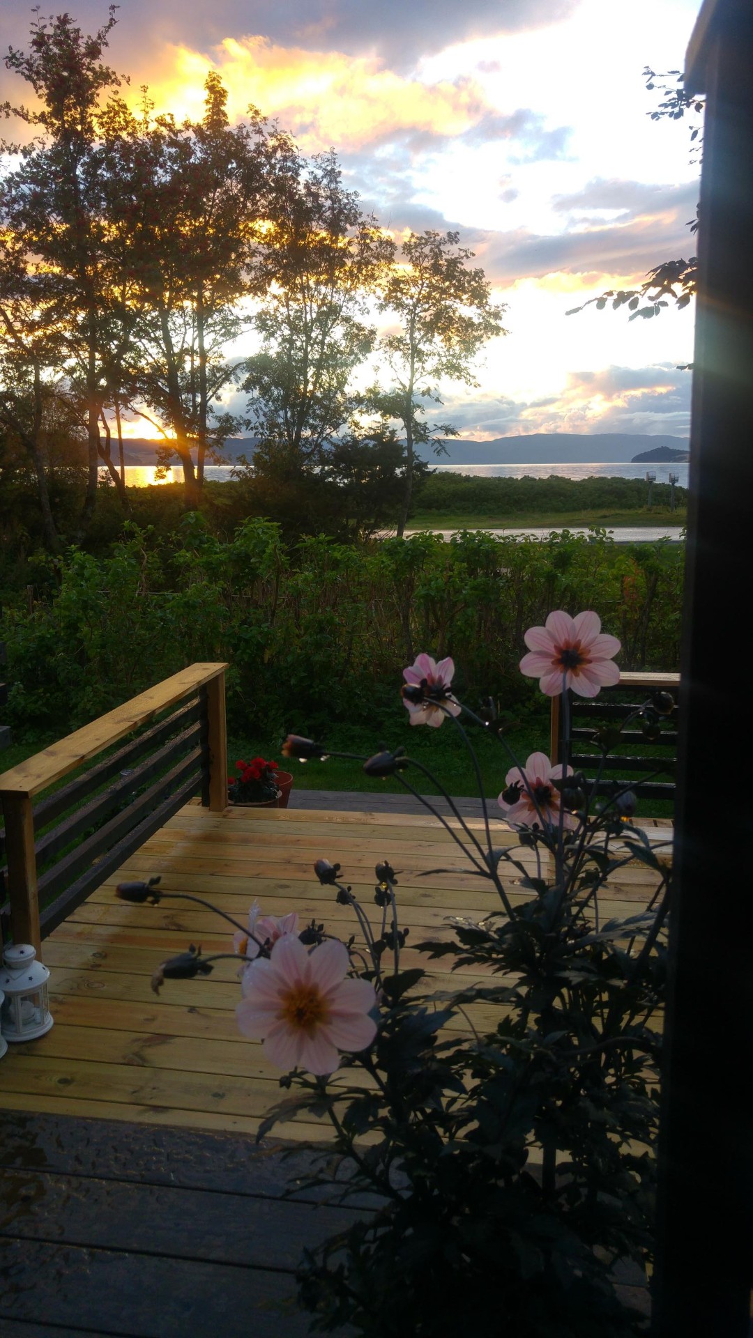 Solnedgang over fjorden sett fra terrassen på Strandheimen
